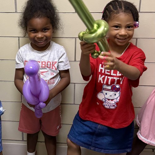 Two kids with their balloon swords at a school carnival, August 2026