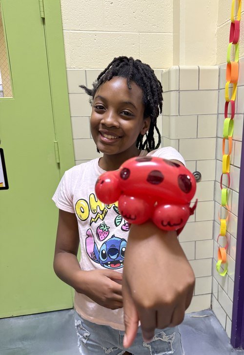 A young girl with her balloon turtle bracelet at a school carnival, August 2026