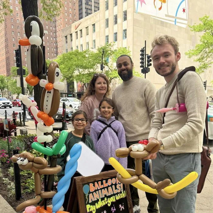 Michael Romani posing with a family in front of the Starbucks Reserve on Michigan Avenue, May 2026