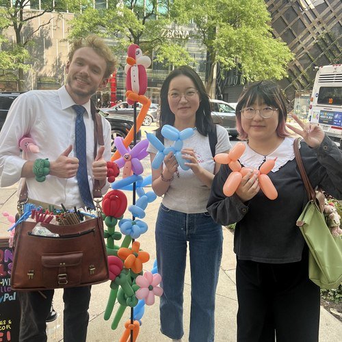 Michael Romani posing with two customers and their balloon dogs, July 2026