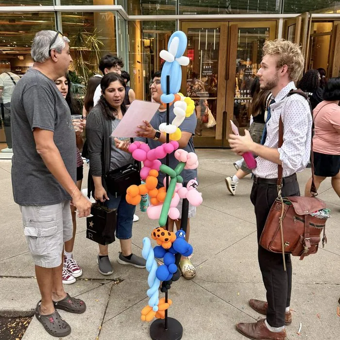 Michael Romani chatting with a family in front of the Starbucks Reserve on Michigan Avenue, Labor Day weekend 2026