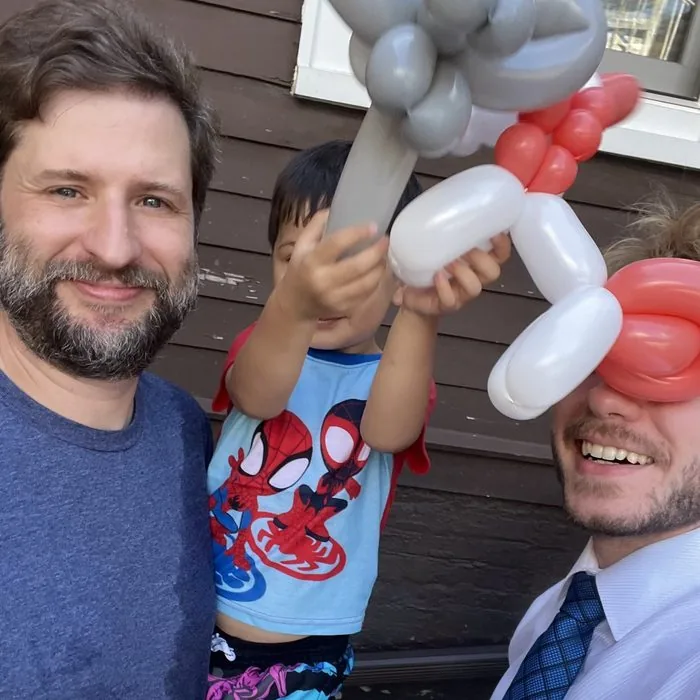 Michael Romani at an Old Irving Park birthday party with a child's pony and elephant balloons, late August 2026