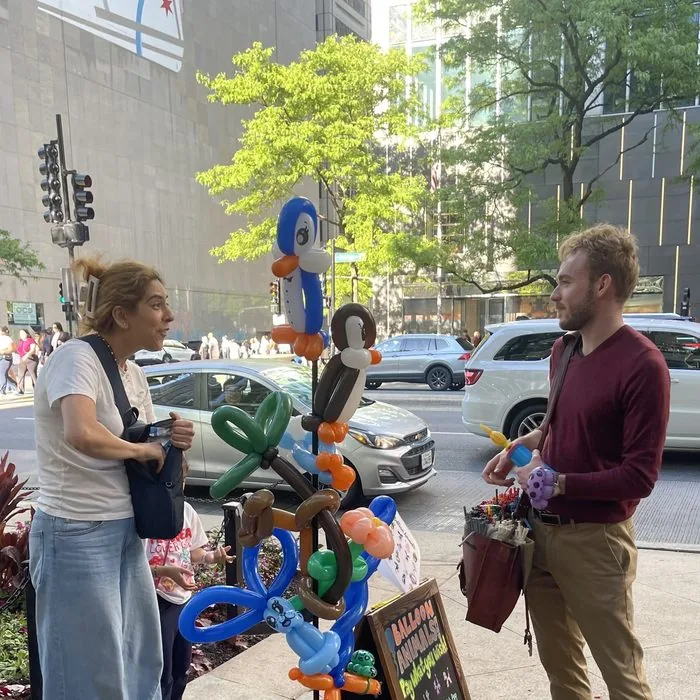 Michael Romani discussing balloons with a customer on Michigan Avenue, Labor Day weekend 2026