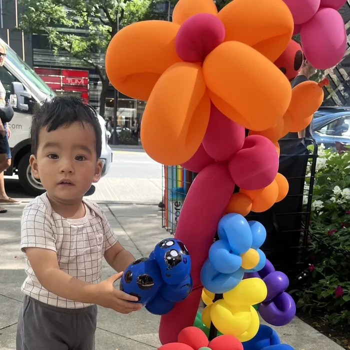 A young child playing with Michael's balloon display on the Magnificent Mile