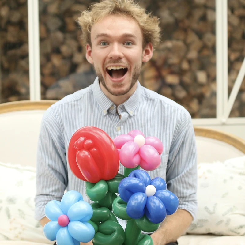 Michael Romani smiling with a bouquet of balloon flowers